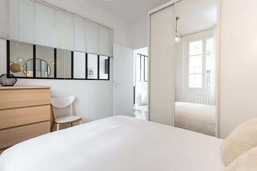 Chambre avec une vue sur le salon par une verrière