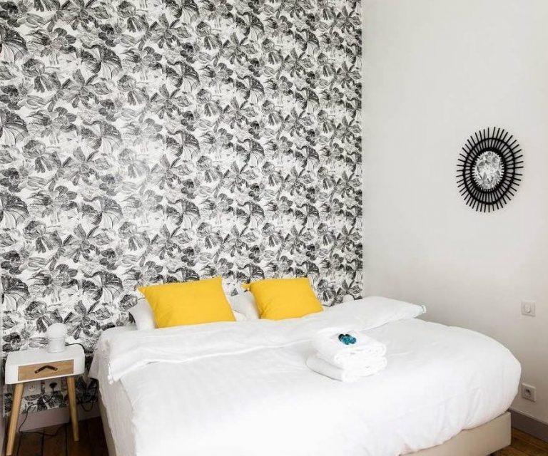 Vue d'une chambre avec un papier peint végétal noir et blanc
