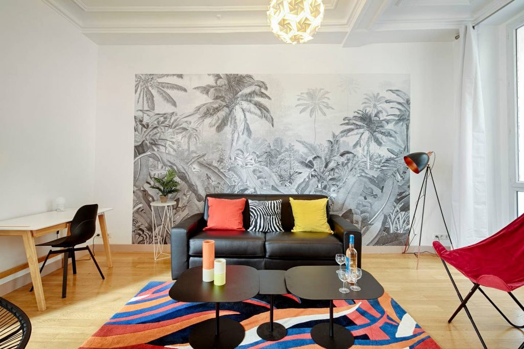 décoration d'un appartement avec des accessoires colorés et un papier peint noir et blanc