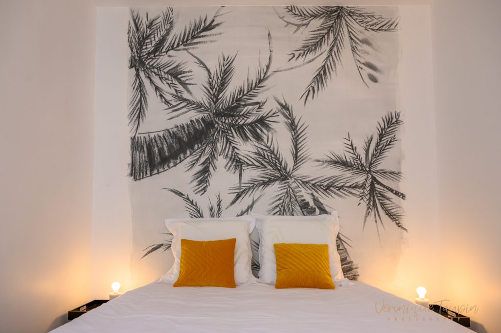 Une chambre décorée par Liza Lena avec un papier peint à palmiers