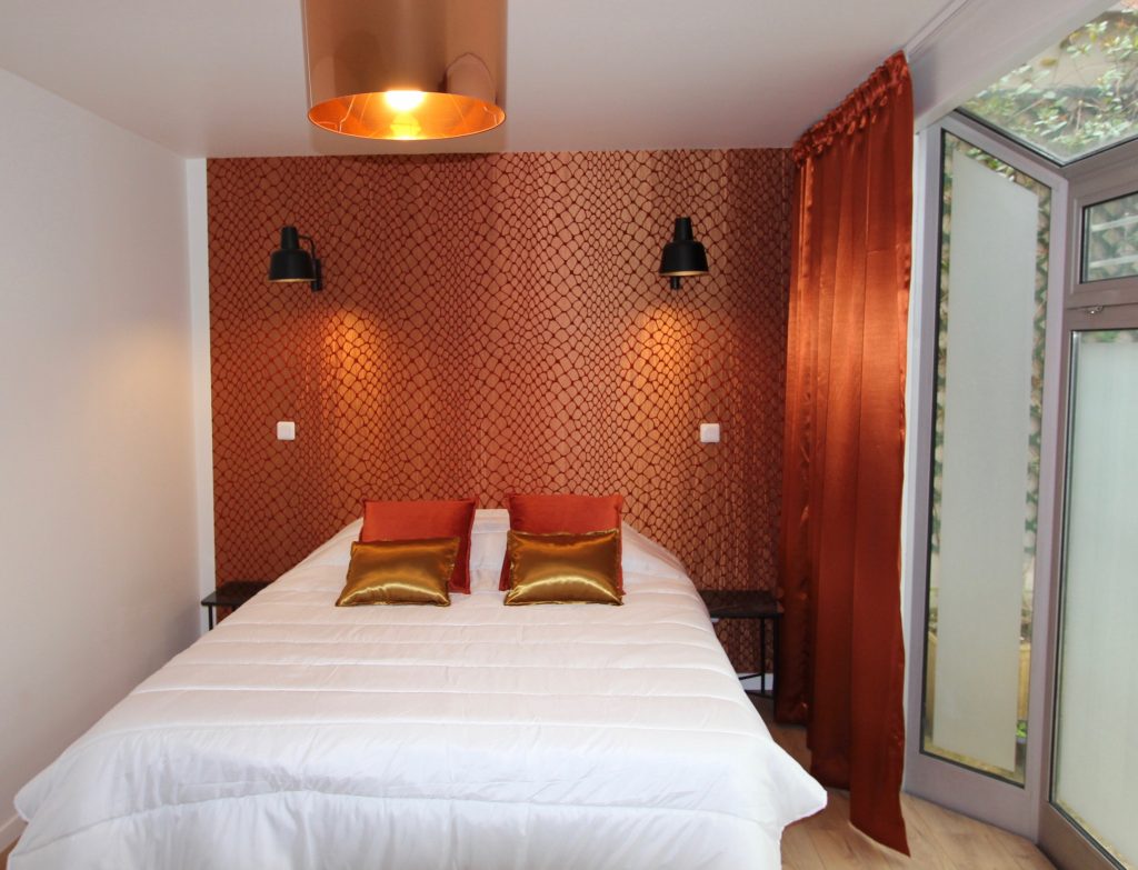 Vue d'une chambre avec un papier peint cuivré orangé