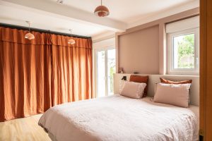 Photo d'une chambre redecoree par Liza Lena avec un lit rose poudré et des rideaux en lin terracotta