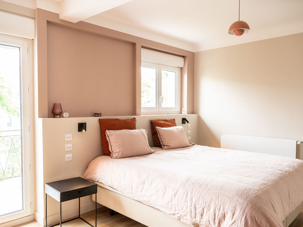 Photo d'une chambre avec une niche en tete de lit et du linge de lit en lin